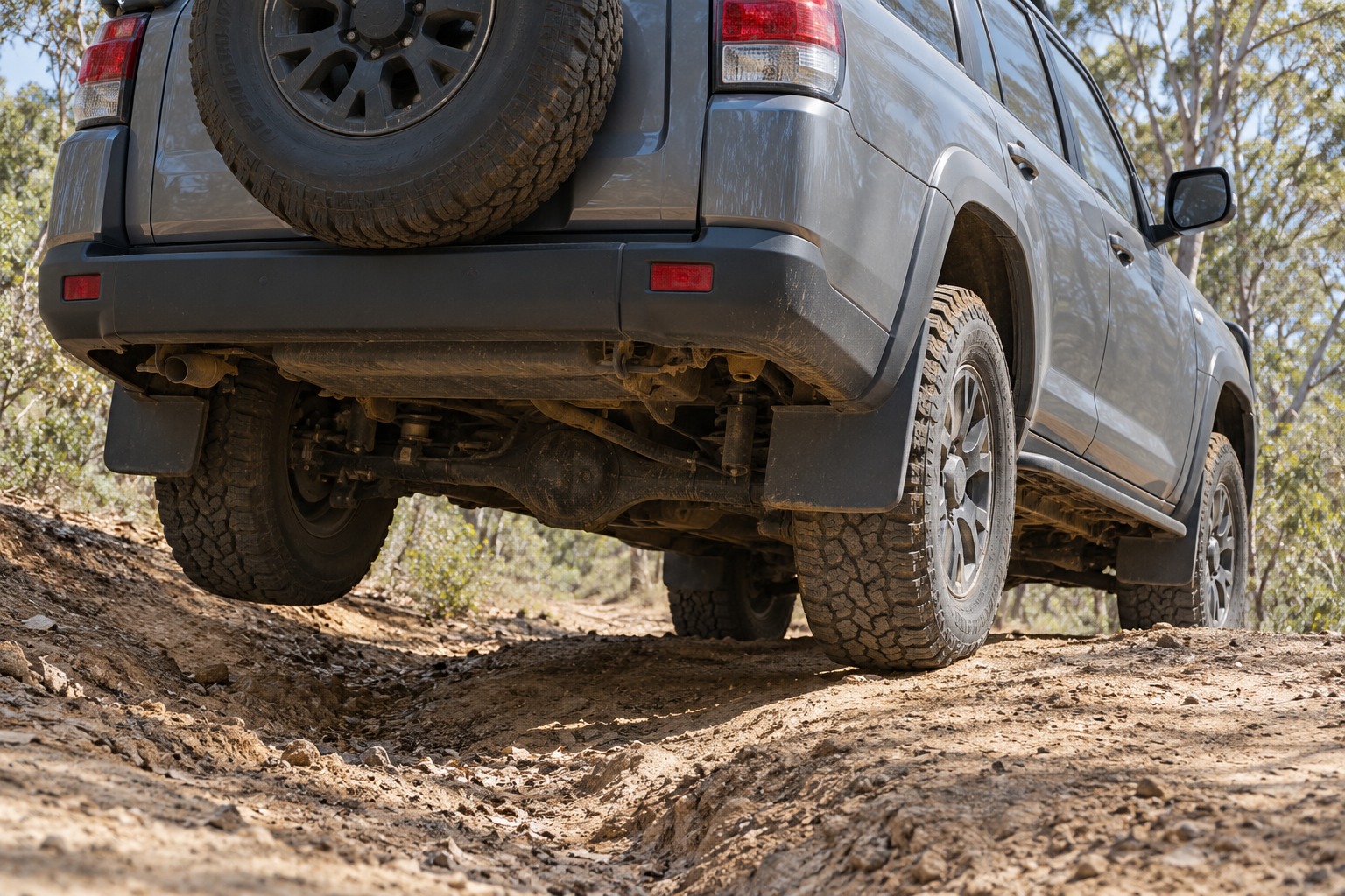 Rear axle articulation on an uneven dirt track leaves one rear tyre above the ground.